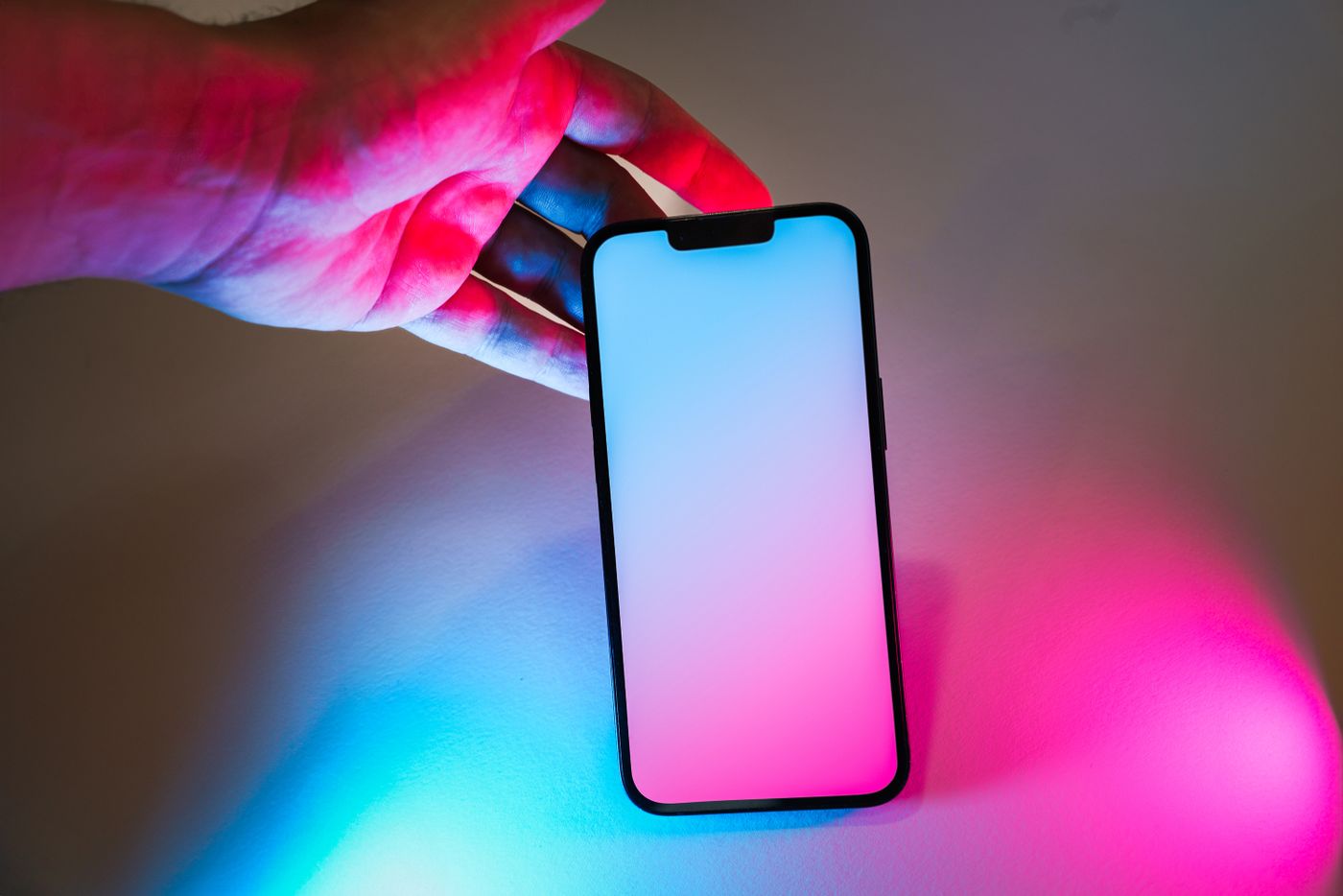 Smartphone illuminato da luci ciano e magenta
